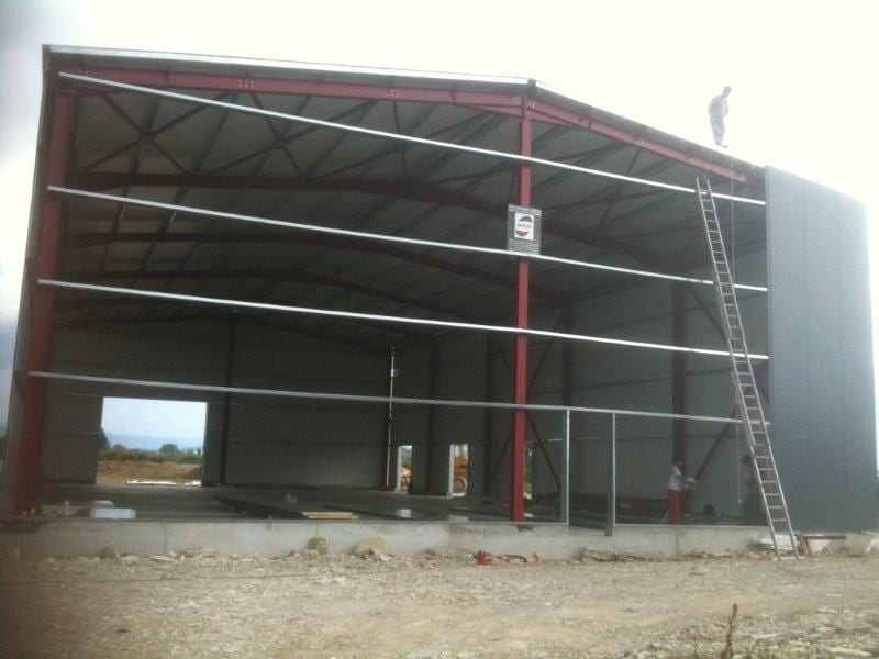 Installing insulated panels on the steel frame of the warehouse on the plain of Arta