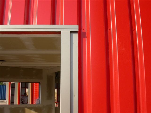 Window frame detail in red metal sheet cladding at the Aspropyrgos vehicle inspection center