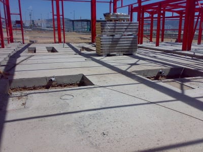 Foundation slab with anchor bolt pockets in front of the frame of the vehicle inspection center in Aspropyrgos