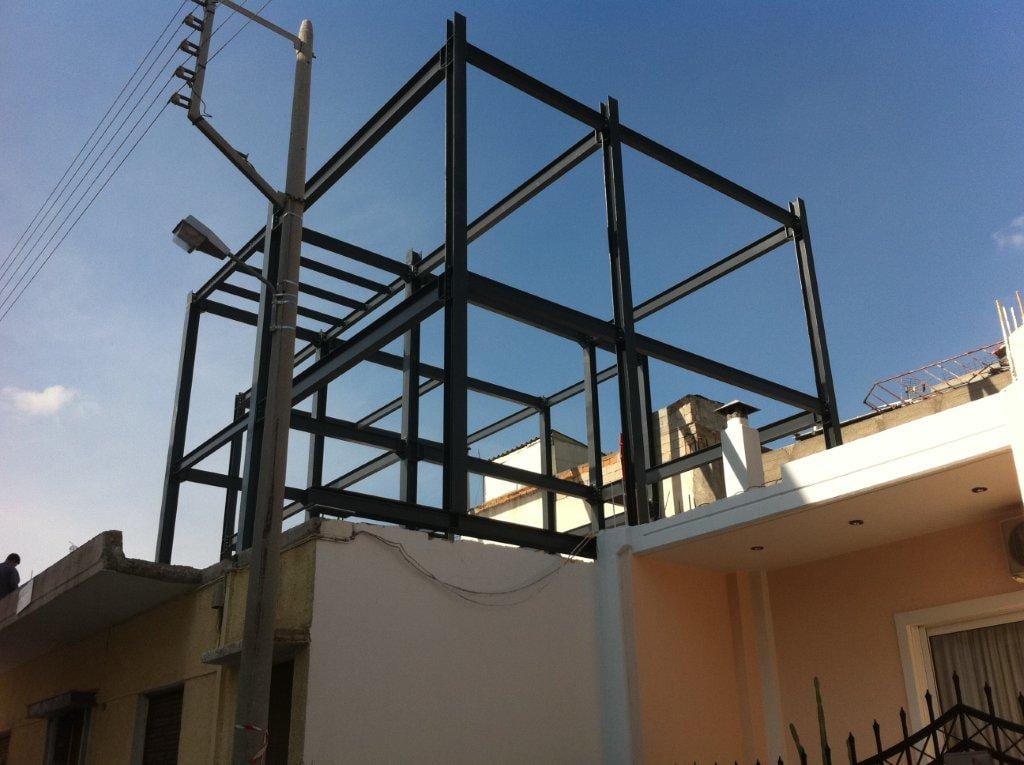 Erection of the steel frame of a two-story vertical addition on an existing house in Chaidari