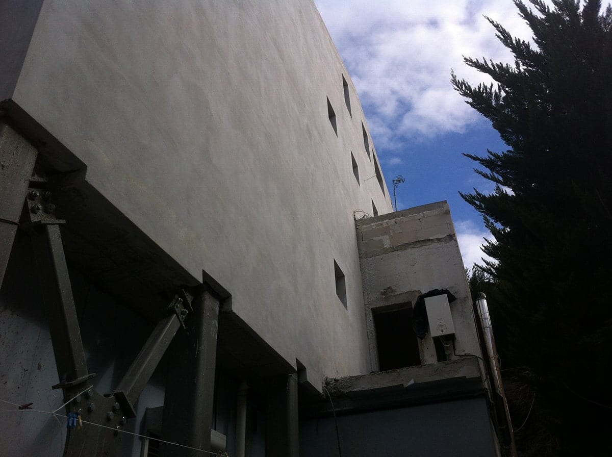 Plastered walls above the steel exoskeleton of the extension in Melissia