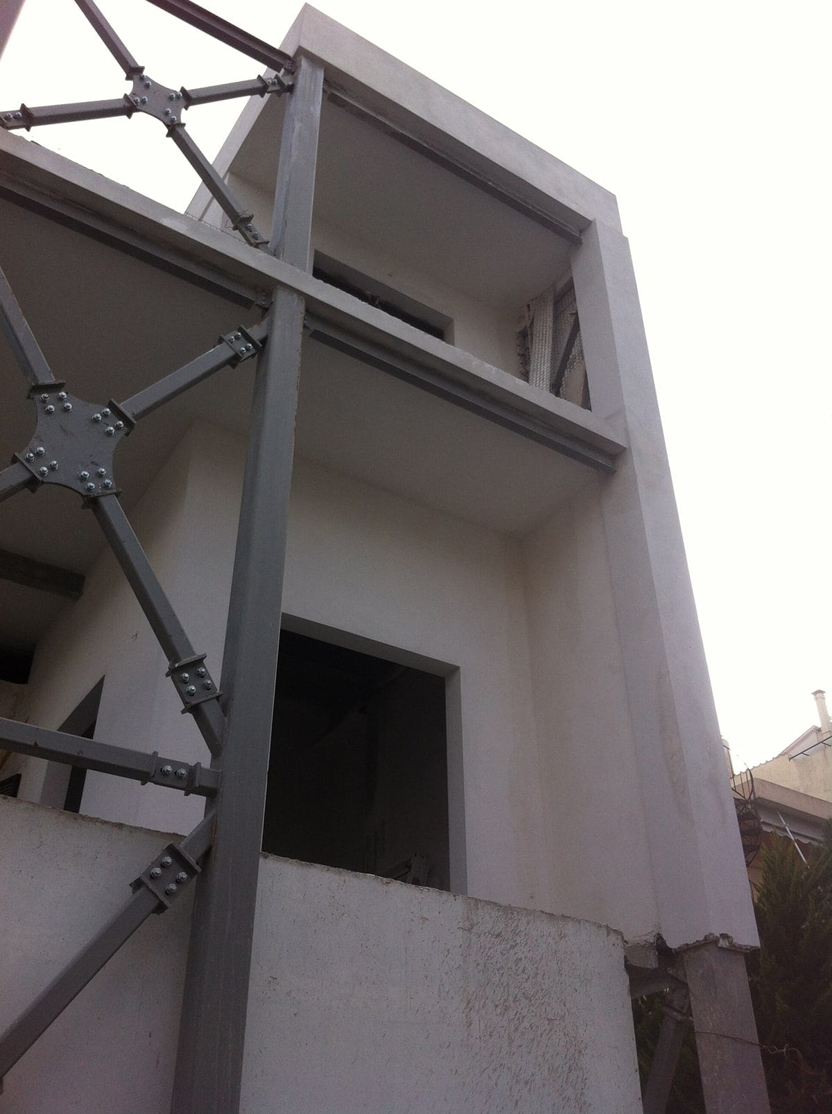 Steel exoskeleton with bolted connections in front of the new stories in Melissia