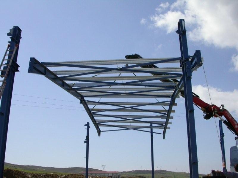 Lifting part of the roof with a crane onto the steel frame in Karystos