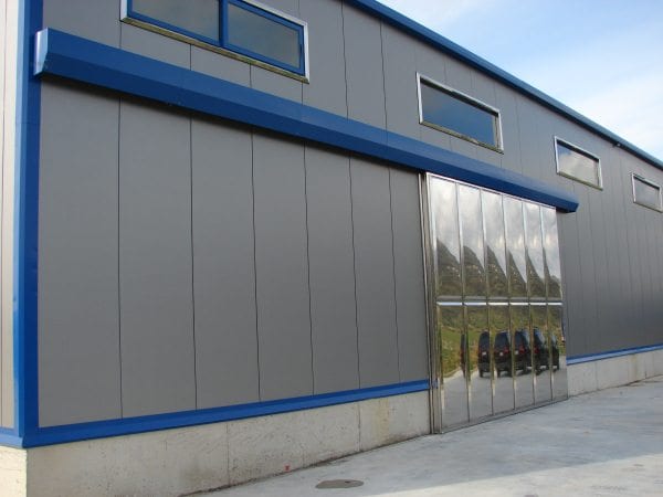 Side view of the steel building with a stainless steel sliding door in Karystos, Evia