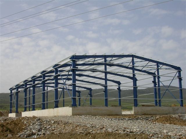 Steel frame with overhead crane brackets during construction in Karystos