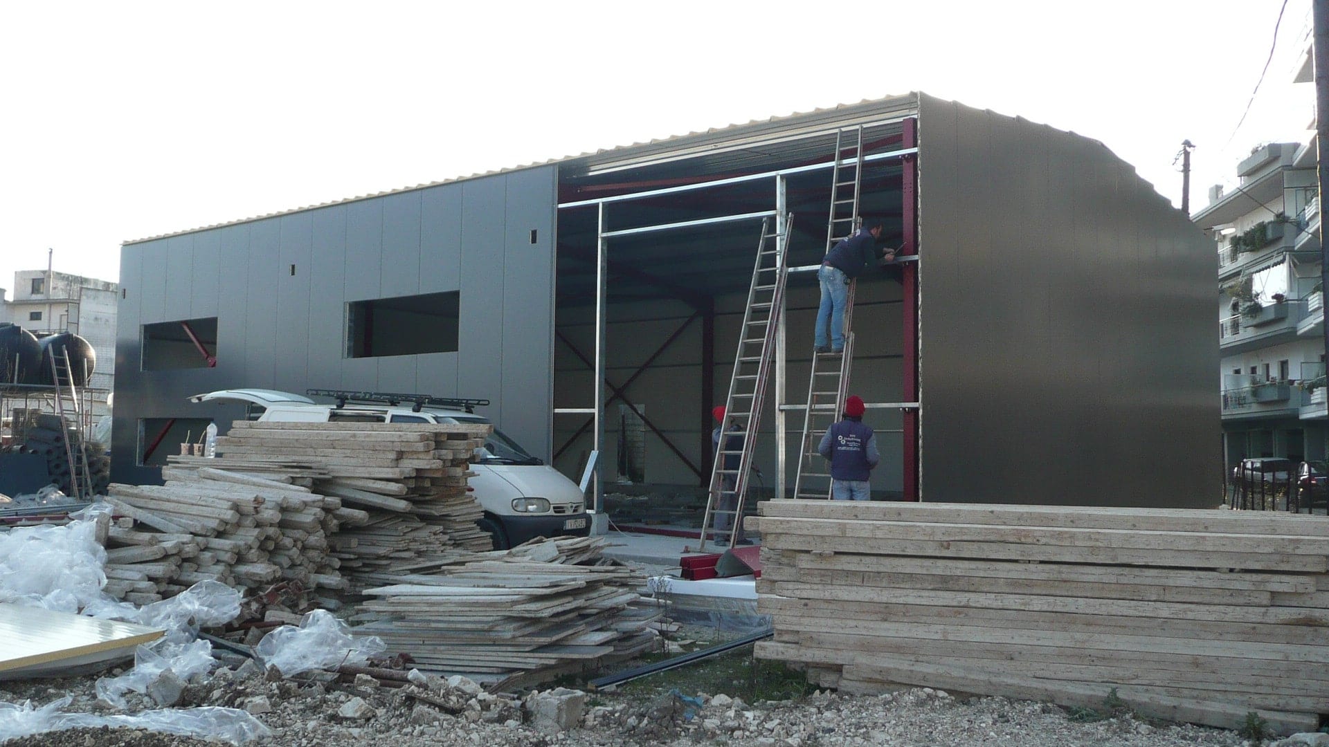 Workers installing wall cladding panels on the olive oil warehouse in Ioannina