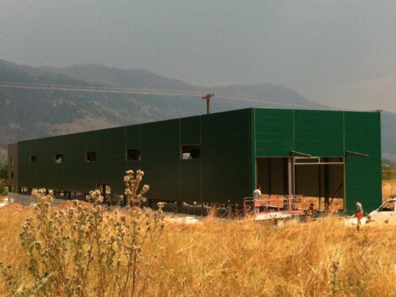 The workshop building on the Eleousa plain with completed green panel wall cladding