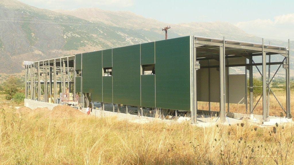 Installing green wall cladding panels on the workshop building in Eleousa