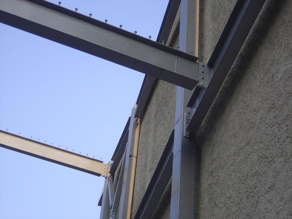 Detail of beam connections of the guesthouse frame against the wall of the neighboring building