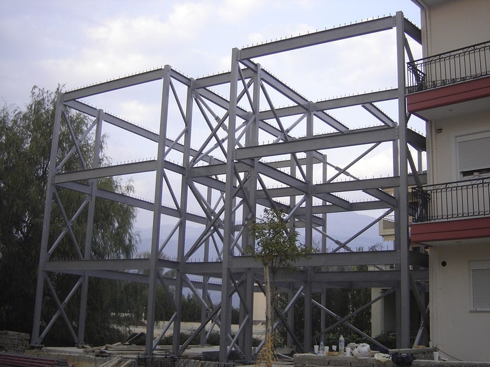 Completed steel frame of the guesthouse in Ioannina next to a neighboring building