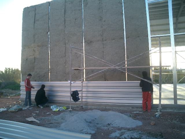 Workers installing horizontal metal wall cladding sheet at the Modeco showroom in Asprochoma