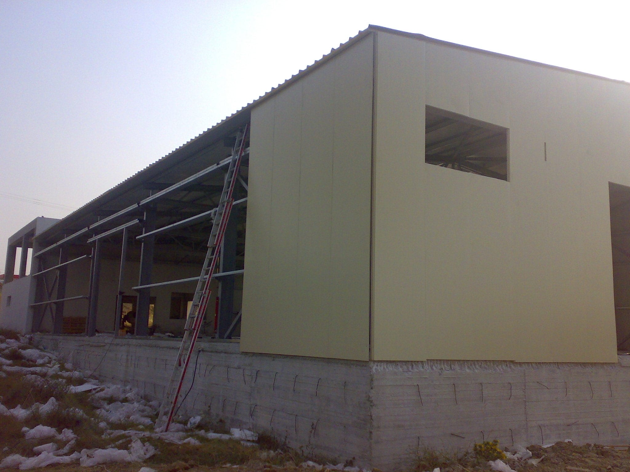 Installing wall cladding panels at the animal feed store in Chorepiskopi, Corfu