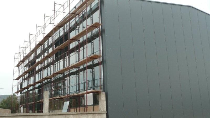 Insulated panel wall cladding and scaffolding on the front of the building in Aspropyrgos, Attica
