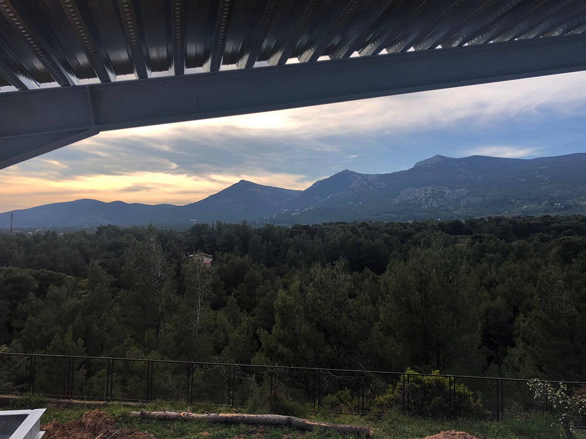 View toward the mountains beneath the steel slab of the maisonette in Varympompi