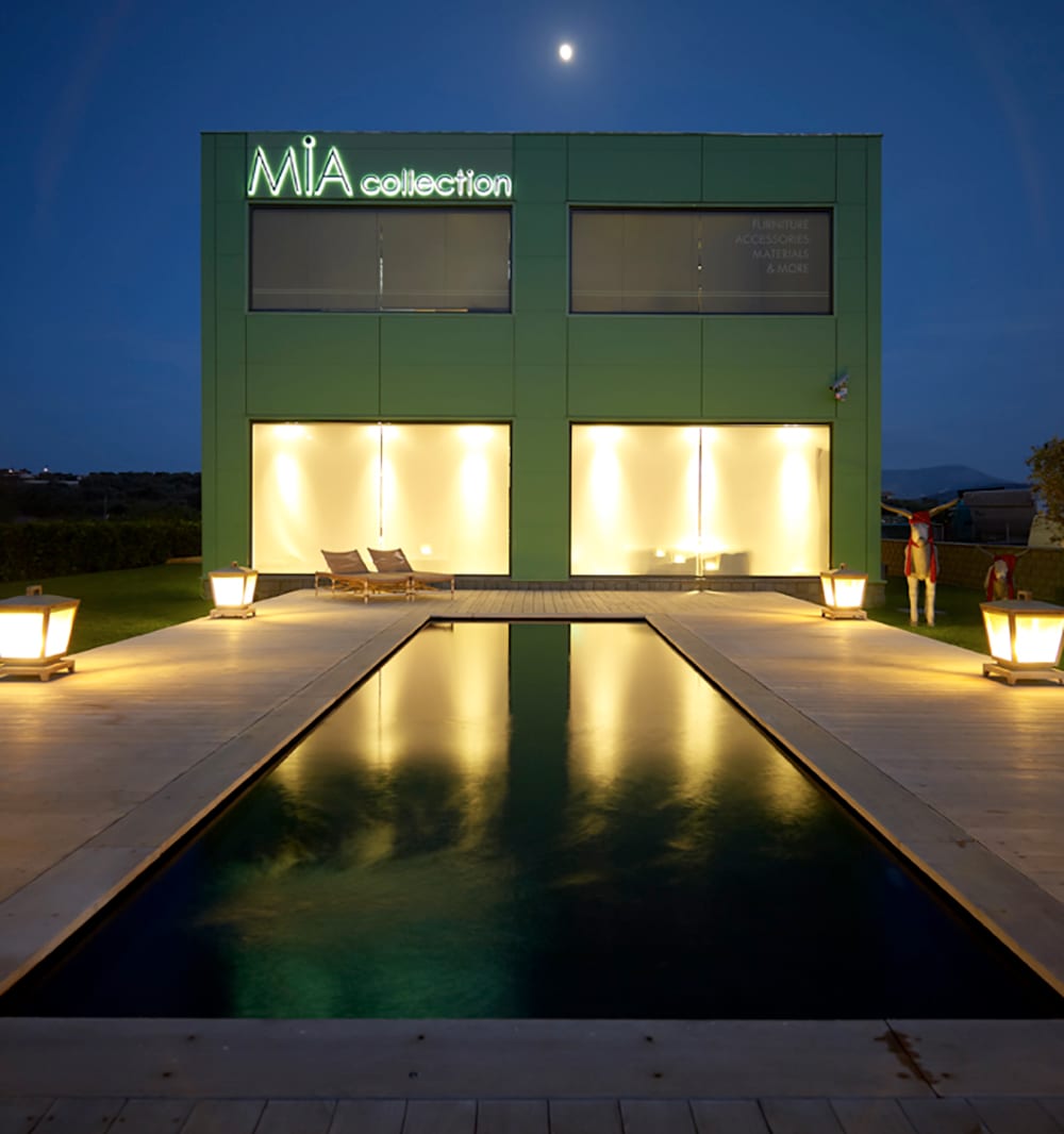 Νυχτερινή όψη του καταστήματος Mia Collection με πισίνα στο Κορωπί