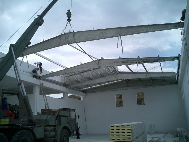 Placing steel roof beams by crane at the carpentry workshop in Filoti, Naxos