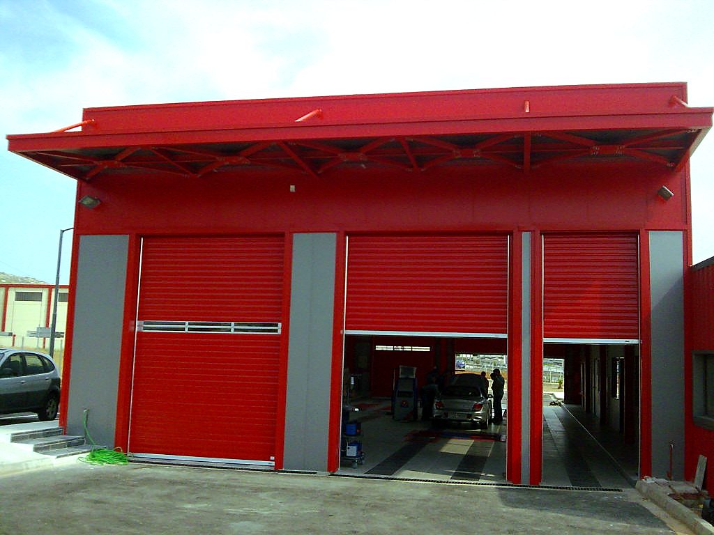 Entrance of the vehicle inspection lanes with roller doors and steel canopy at the Aspropyrgos vehicle inspection center