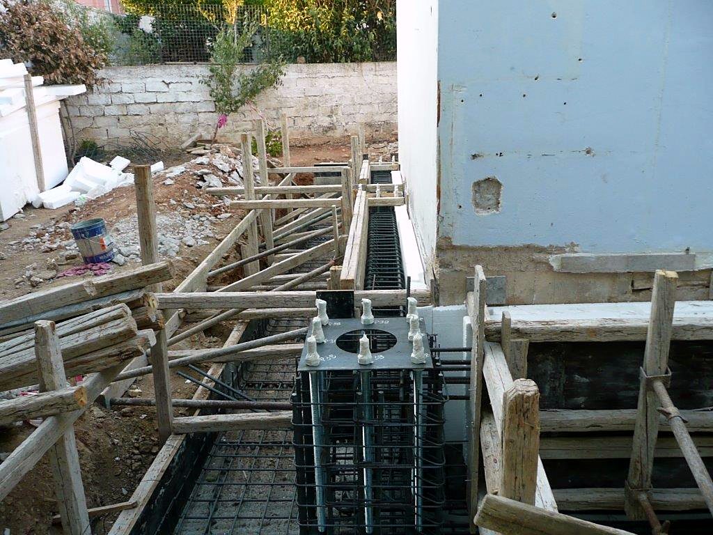 Foundation pedestal reinforcement with anchor bolts and a template for a steel column, house extension in Melissia