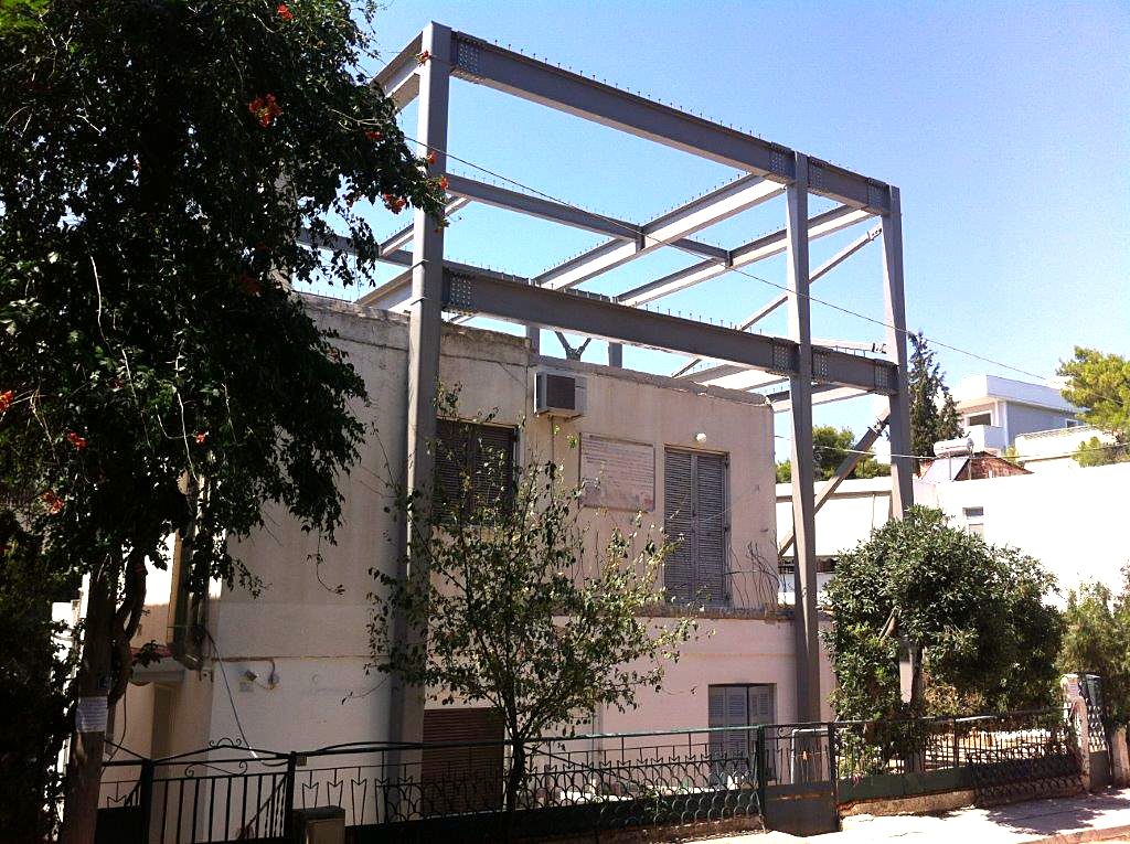 Side view of the steel frame of a house extension with columns outside the existing building, Melissia