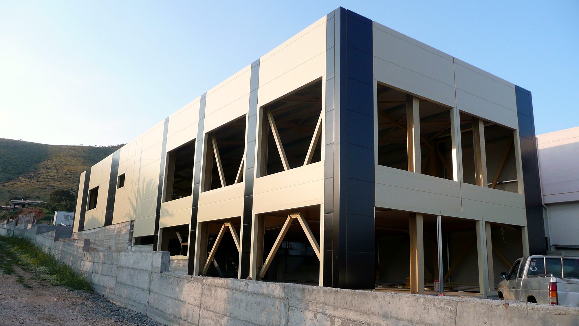 Two-story steel frame with diagonal bracing and facade panels on a store in Marathon, Attica