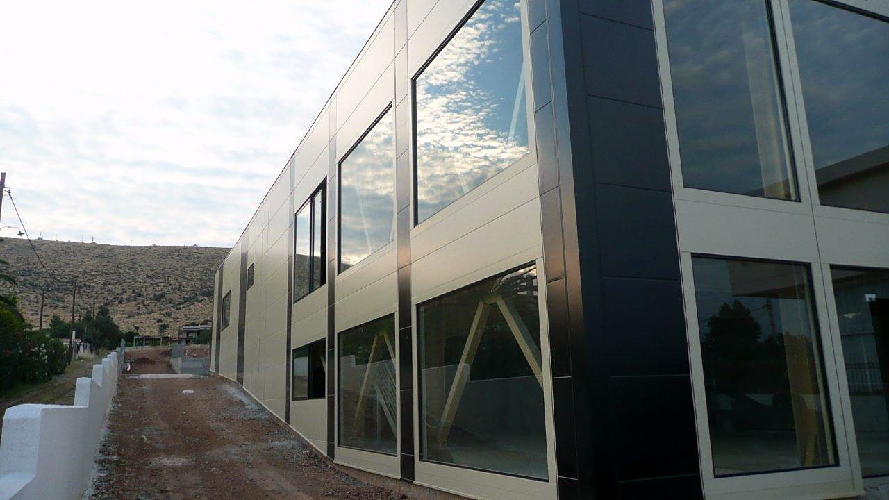 Two-story steel showroom building with glazing and facade panels in Marathon, Attica