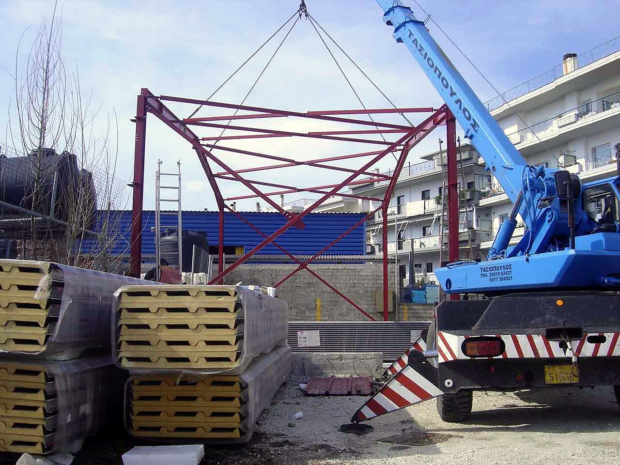 Lifting a steel frame with a crane, with polyurethane insulated panels on site, warehouse in Ioannina