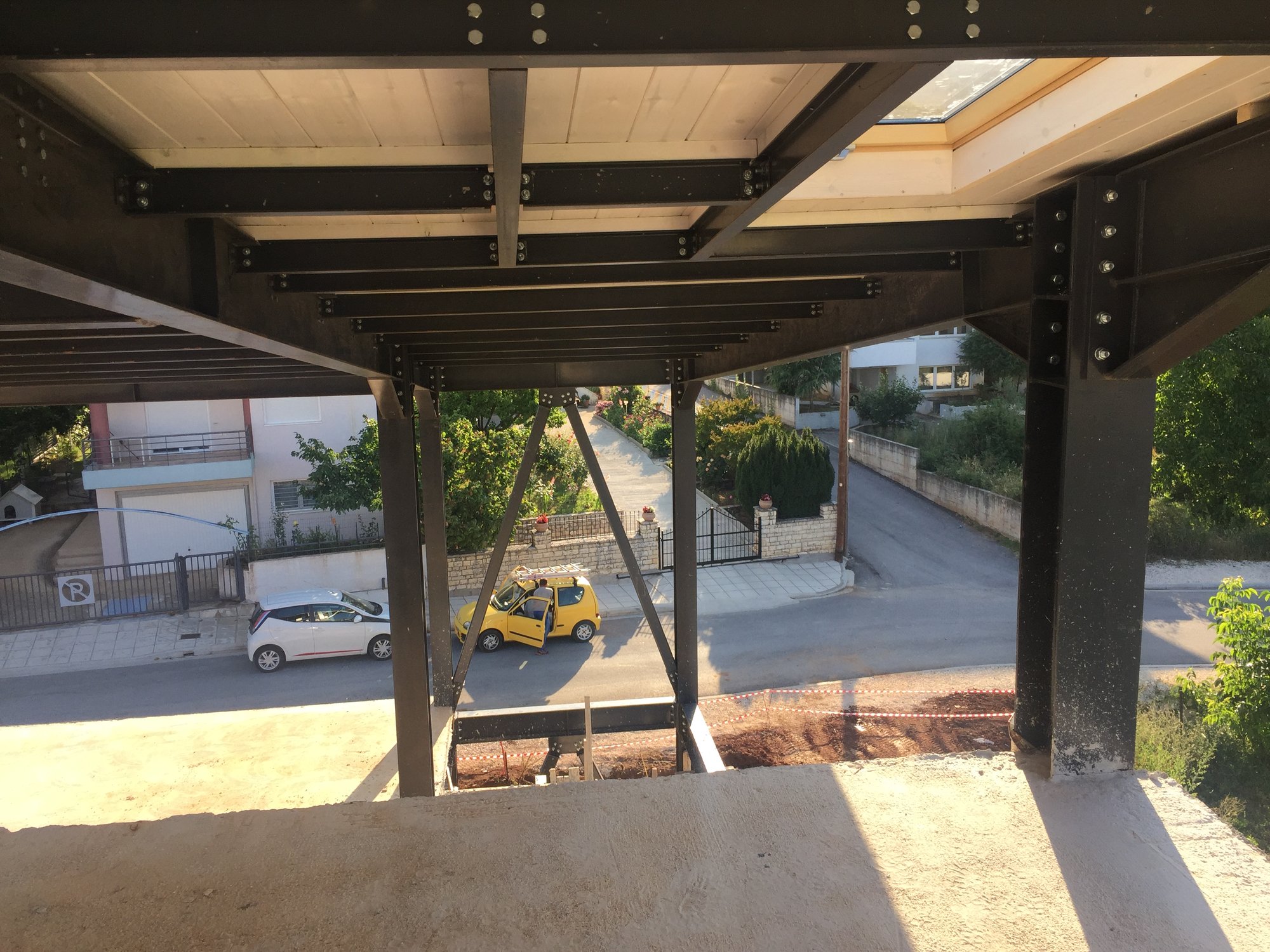 Bolted beam and column connections under the slab, House with basement, pilotis and attic in Neochoropoulo |