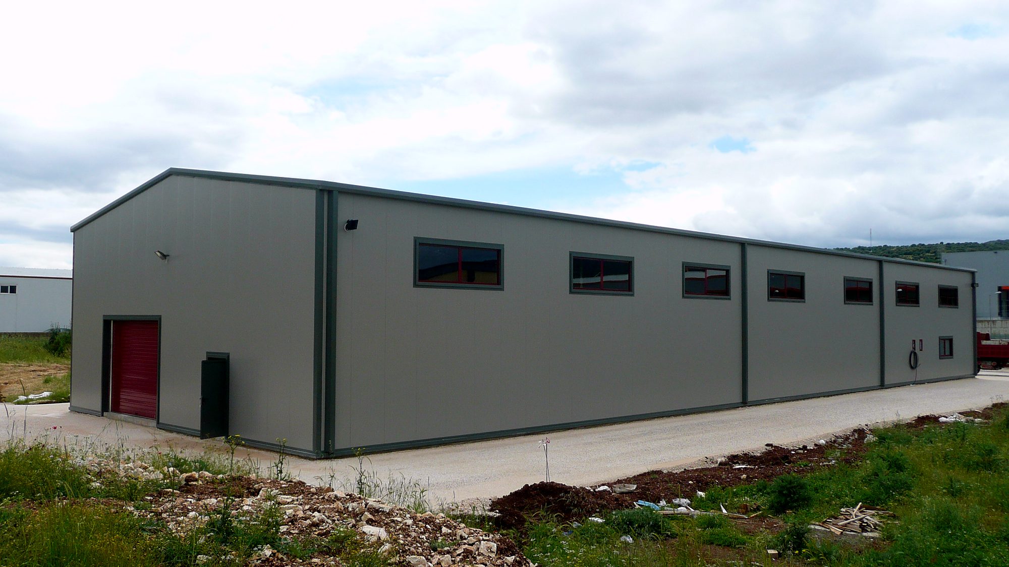 Side view of a steel light-industrial warehouse with panels in the Ioannina industrial zone