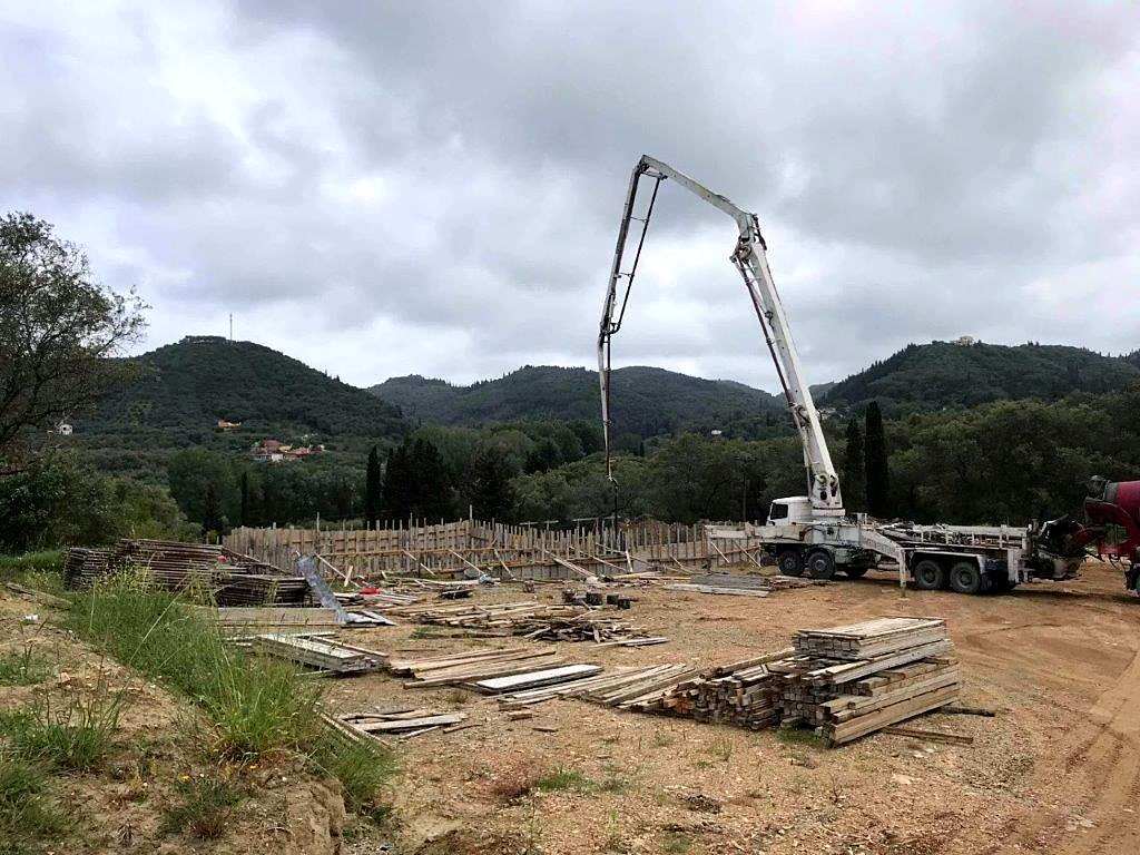 Pouring the foundation concrete with a pump at the site of a warehouse building in Arillas, Corfu