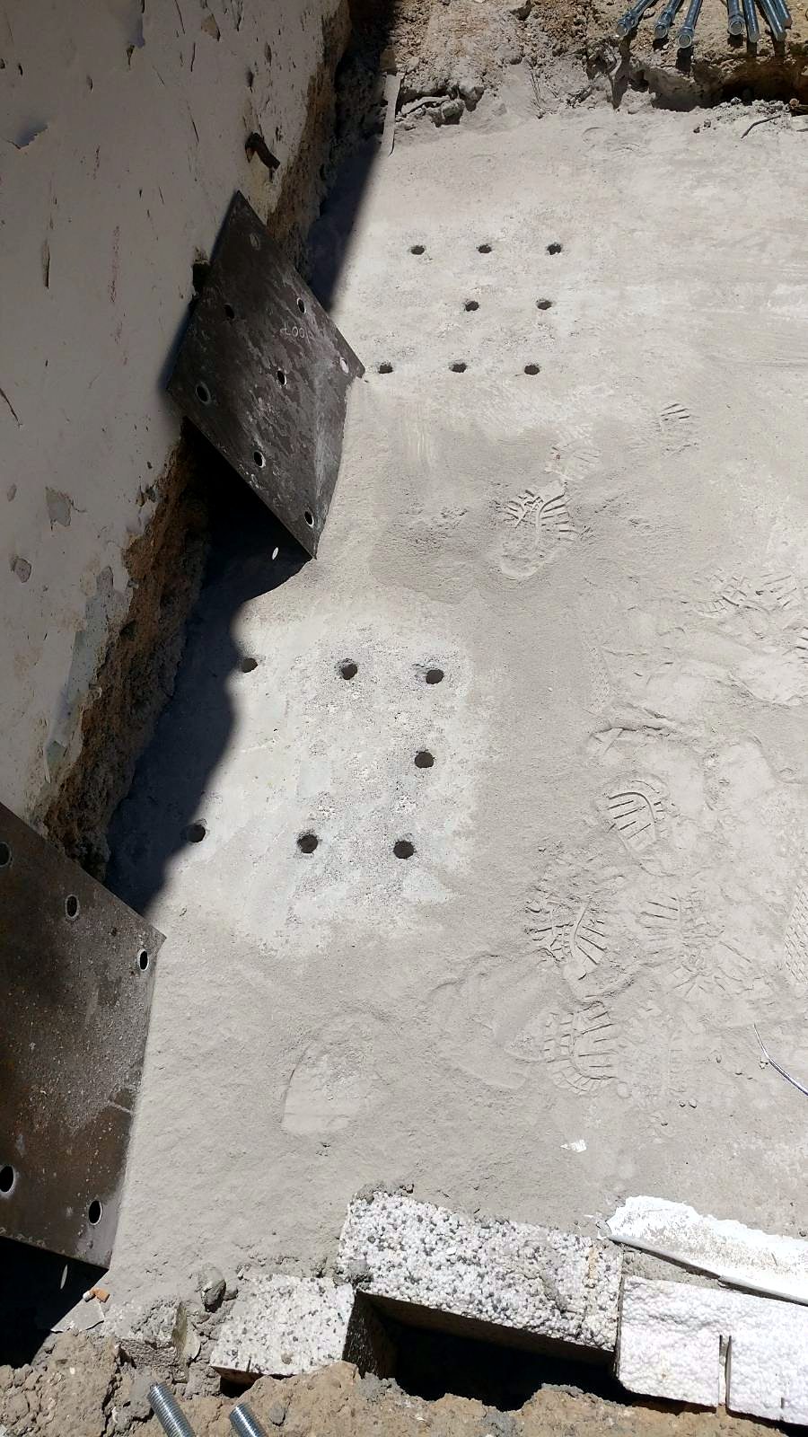 Steel anchor plates fixed to an existing basement wall for a steel and concrete building in Ano Petralona