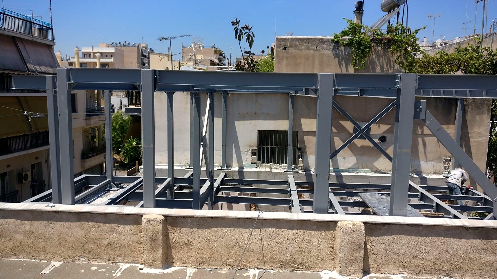Steel frames with cross bracing on the upper floor of a steel and concrete building in Ano Petralona