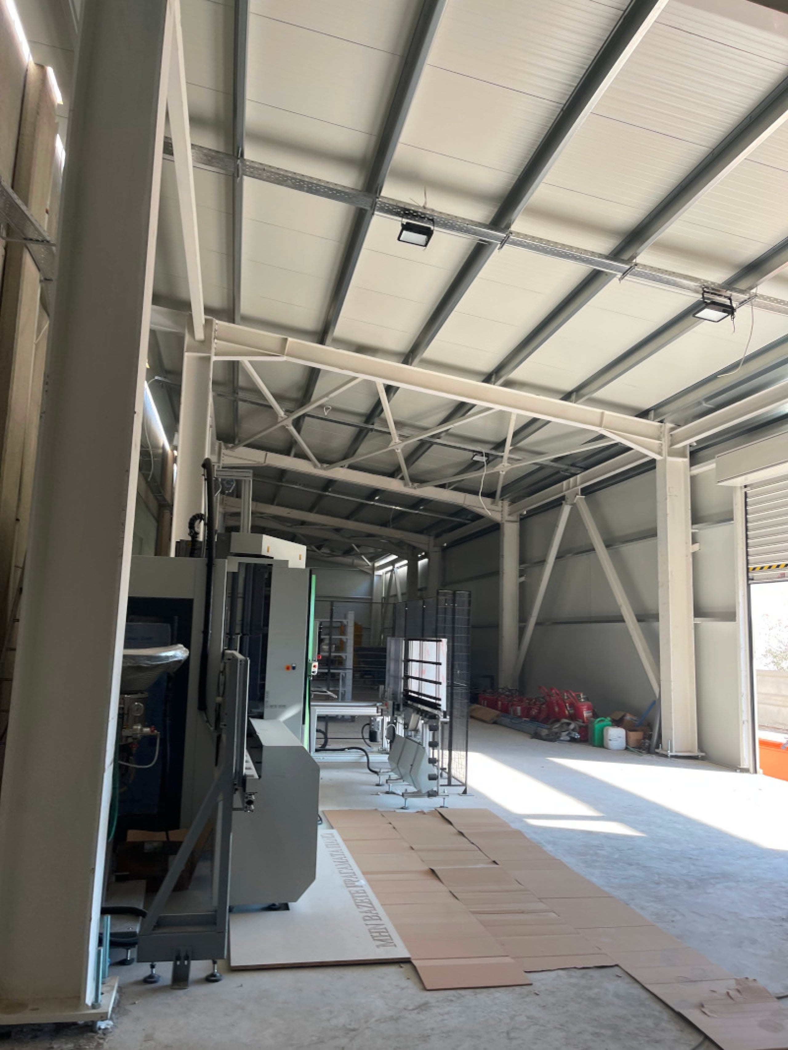 Interior of the production area with steel trusses and woodworking machinery