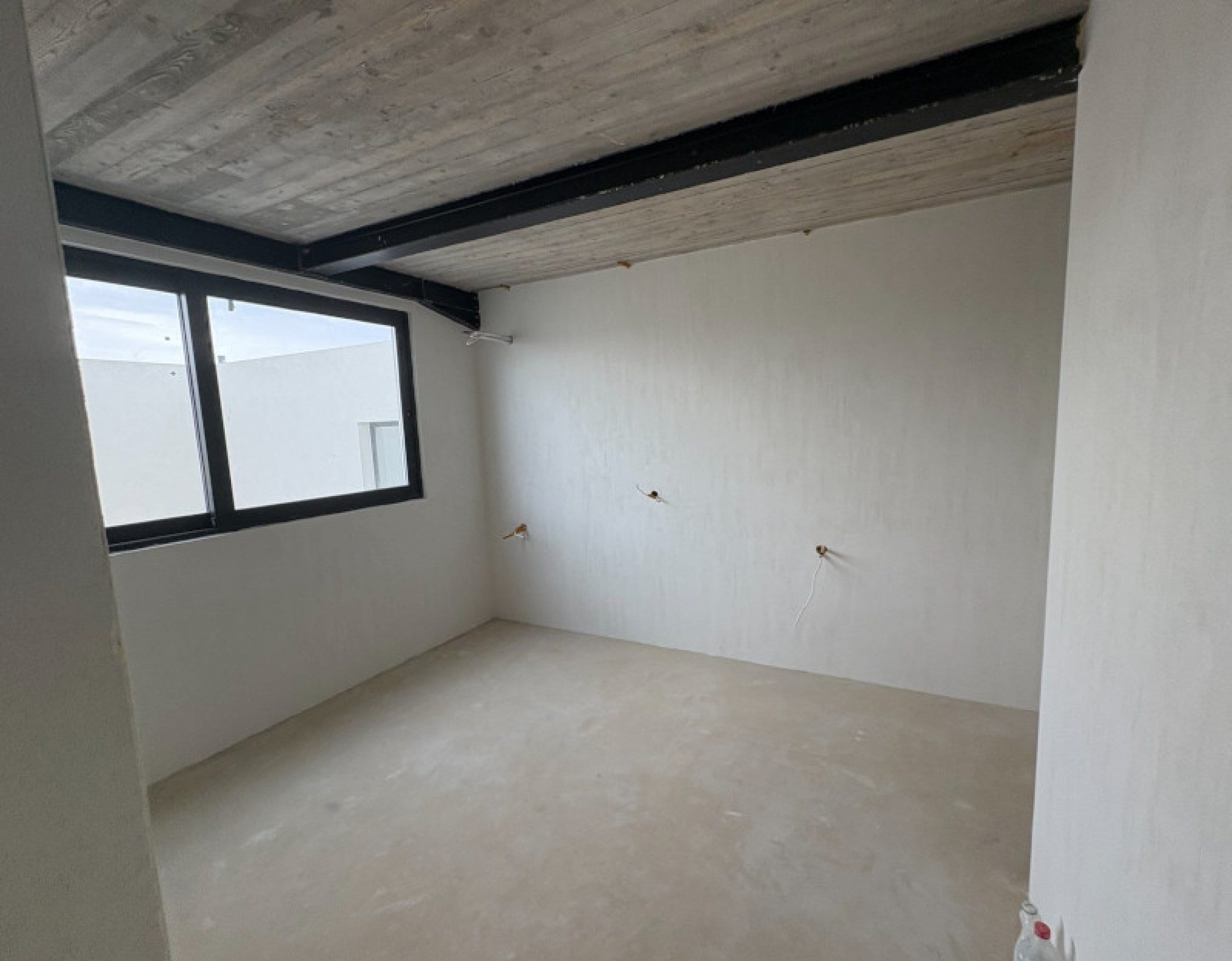 Room interior with exposed steel ceiling beams in the rental rooms on Skyros